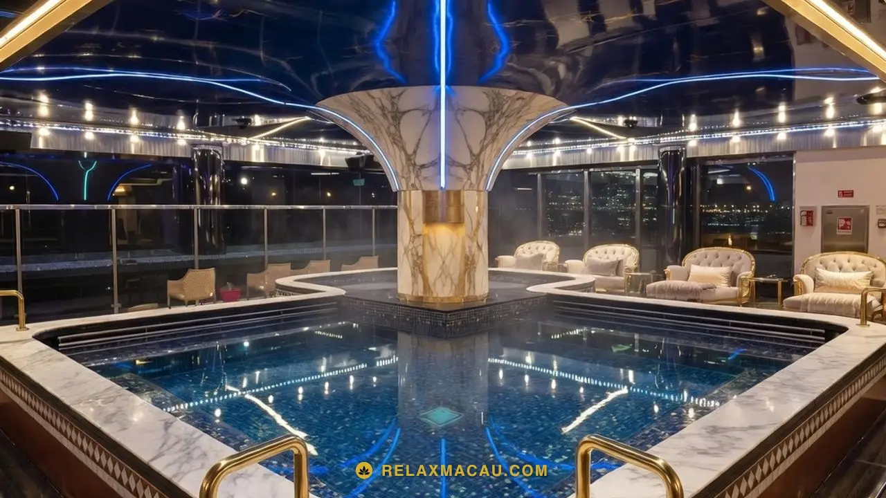Macau sauna bathing hall with a blue-lit mosaic-tiled pool, marble surround and brass handrails